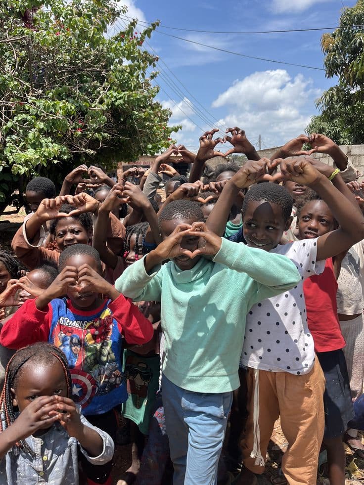Children holding up hand-made hearts at a school programme